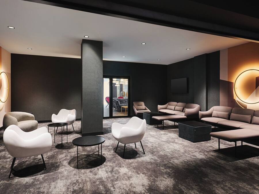 Un área de estar moderna con asientos contemporáneos, iluminación empotrada y vistas a otra habitación.