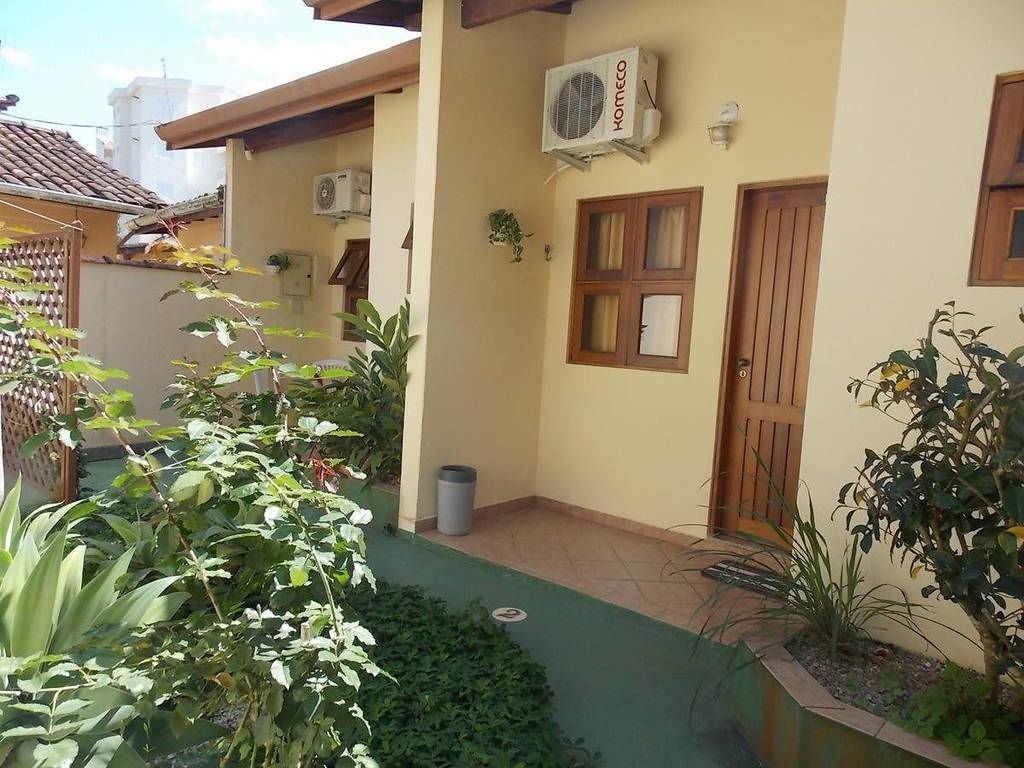 Un edificio residenziale con patio piastrellato, una porta in legno e un condizionatore d'aria.