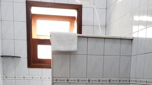 A bathroom with a toilet, sink, and shower. - Pousada Sonhos (Ubatuba)