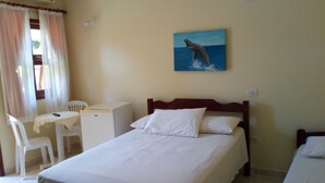 A hotel room with a bed, a desk, and a chair. - Pousada Sonhos (Ubatuba)