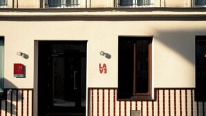 Fachada de edificio con puerta, ventana y un letrero con un logotipo.
