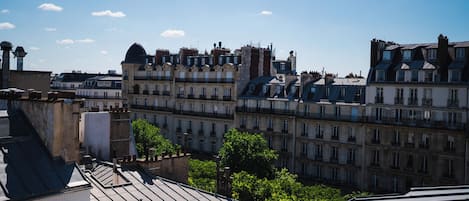 A row of historic European-style buildings with multiple stories and balconies, under a clear blue sky.