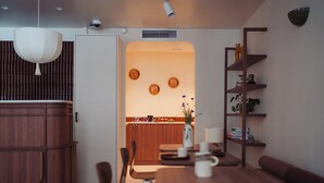Una cocina moderna con comedor, armarios de madera y horno empotrado.