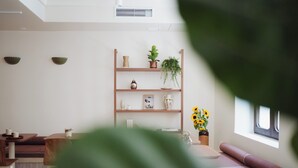 Una habitación moderna con una estantería de madera, una ventana y una planta.