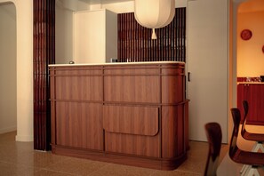 A wooden cabinet with a handle, a white door, and a wall with vertical lines. - Lala Hotel (Paris)
