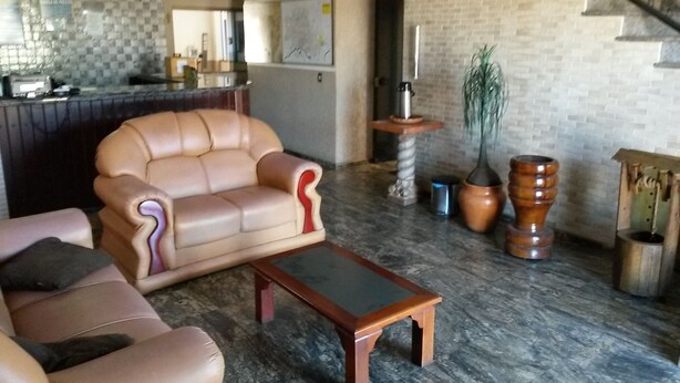 Ein Wohnzimmer mit einem beigen Sofa, einem Holztisch und einer Treppe.