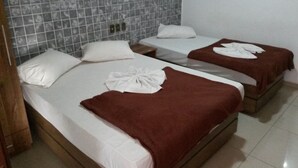 Ein Hotelzimmer mit zwei Betten, jeweils mit weißer Bettwäsche und braunen Handtüchern.