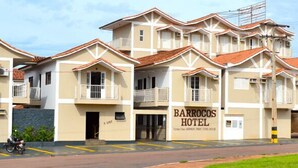 Ein mehrstöckiges Hotel mit symmetrischer Fassade, mehreren Balkonen und einem zentralen Eingang.
