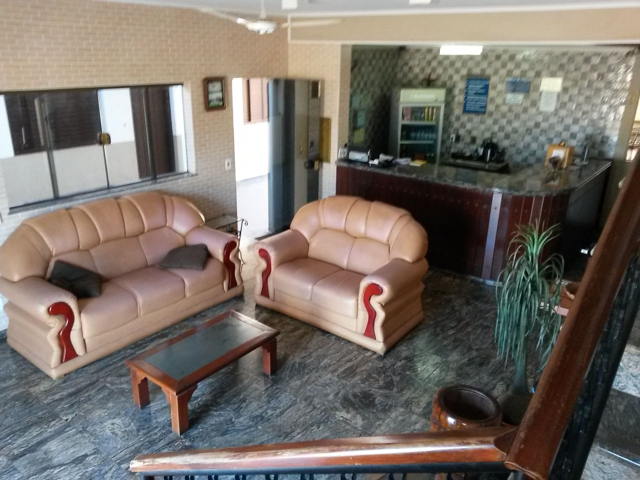 Una sala de estar con dos sofás color beige, una mesa de centro de madera y una silla de madera.