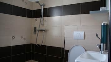 A bathroom with a shower, toilet, and sink.