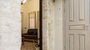 A room with a patterned rug, a sofa, a chair, and a door. - Mark House (Nazareth)
