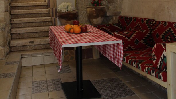 A narrow staircase leading to a landing with a table set with fruit and a checkered tablecloth. - Mark House (Nazareth)