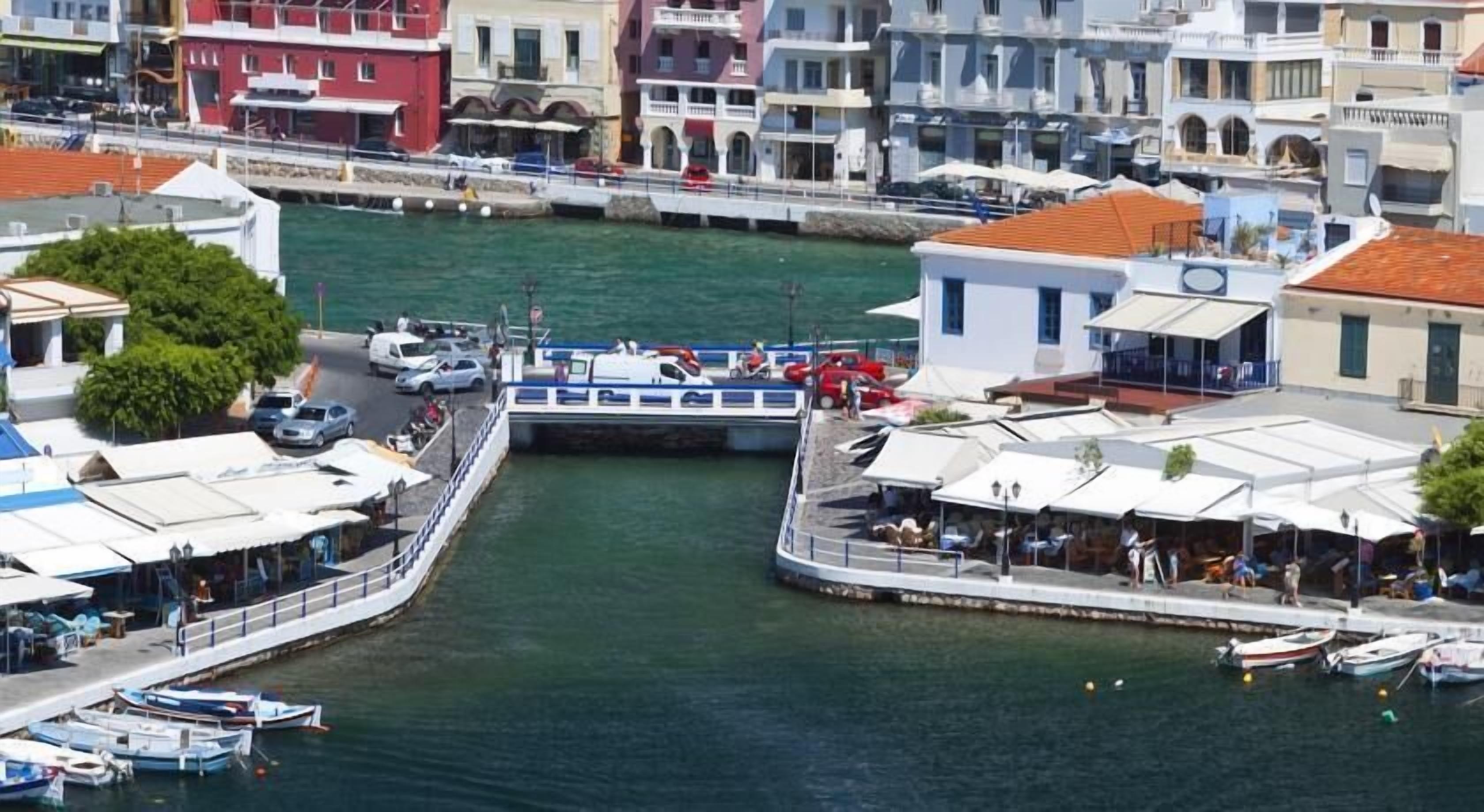 Une zone riveraine avec un bateau amarré, des bâtiments dotés de balcons et un petit quai.