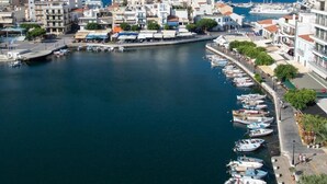 Un pueblo costero con un puerto deportivo, edificios a lo largo del paseo marítimo y barcos amarrados.