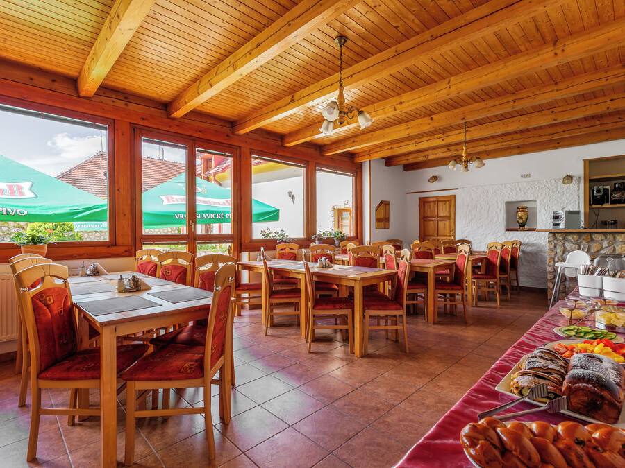 Un restaurante con interiores de madera, varias mesas y sillas.