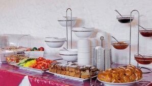 A buffet table with various food items, including fruits, vegetables, and pastries. - Hotel Bella (Prague)