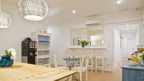 A modern kitchen with white cabinetry, a wooden dining table, and a blue accent wall. - Blue Barcelona (Barcelona)