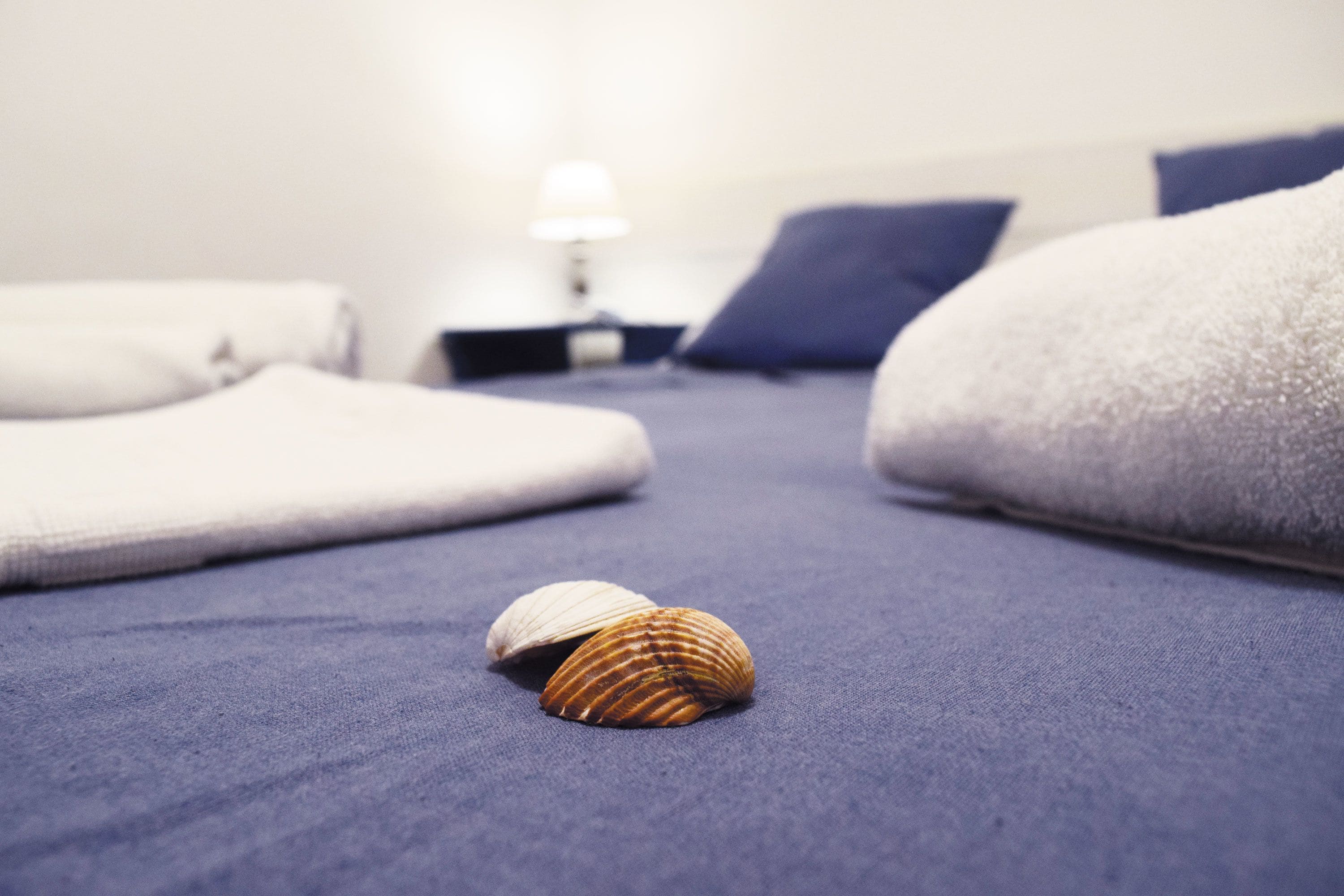A bed with a blue mattress and white pillows.