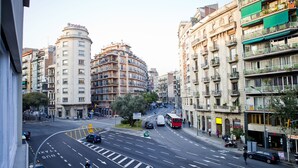 A multi-story building with a curved facade, a visible Vodafone sign, and a street with vehicles and pedestrians. - Blue Barcelona (Barcelona)