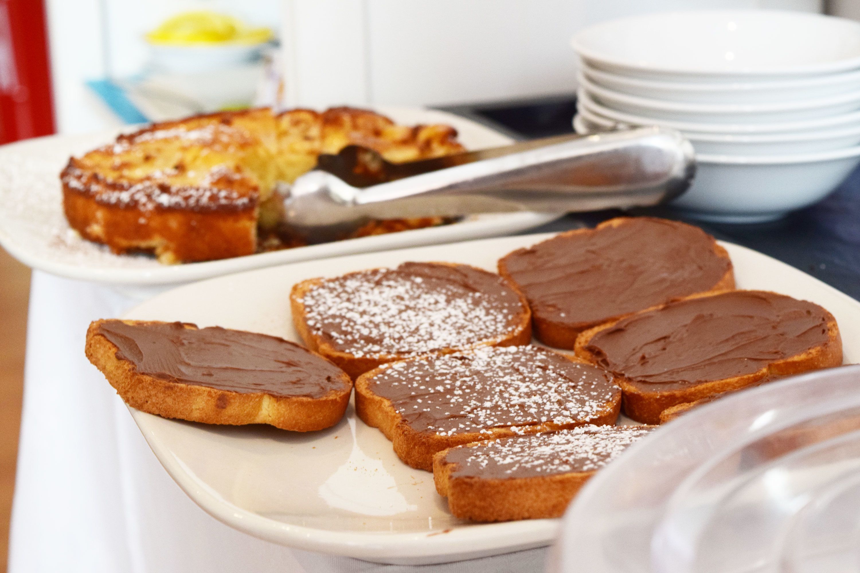 Een bord met toast belegd met chocoladesiroop en poedersuiker.