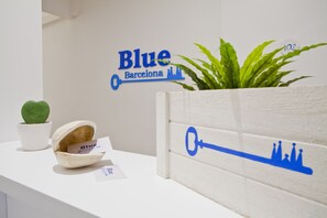 A reception desk with a sign reading "Blue Barcelona" and a decorative key. - Blue Barcelona (Barcelona)
