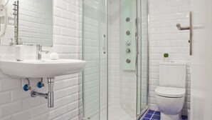 A modern bathroom with a glass-enclosed shower, a white sink, and a toilet. - Blue Barcelona (Barcelona)