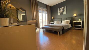 Un dormitorio moderno con una cama grande, mesitas de noche, un escritorio y una planta en maceta.