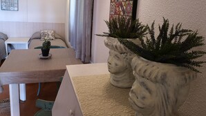 Una habitación acogedora con una cama, una mesita con un cactus, una lámpara de pared y un adorno mural.