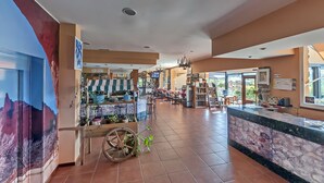 A spacious lobby with a central seating area, a reception desk, and a coffee cart. - Hotel Medulio (Carucedo)