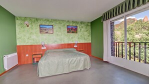 A bedroom with a bed, two wall-mounted lamps, a radiator, and a window with a balcony. - Hotel Medulio (Carucedo)