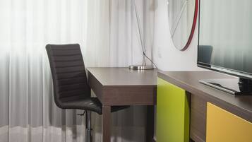 Un espacio de oficina moderno con escritorio, silla y un monitor grande.