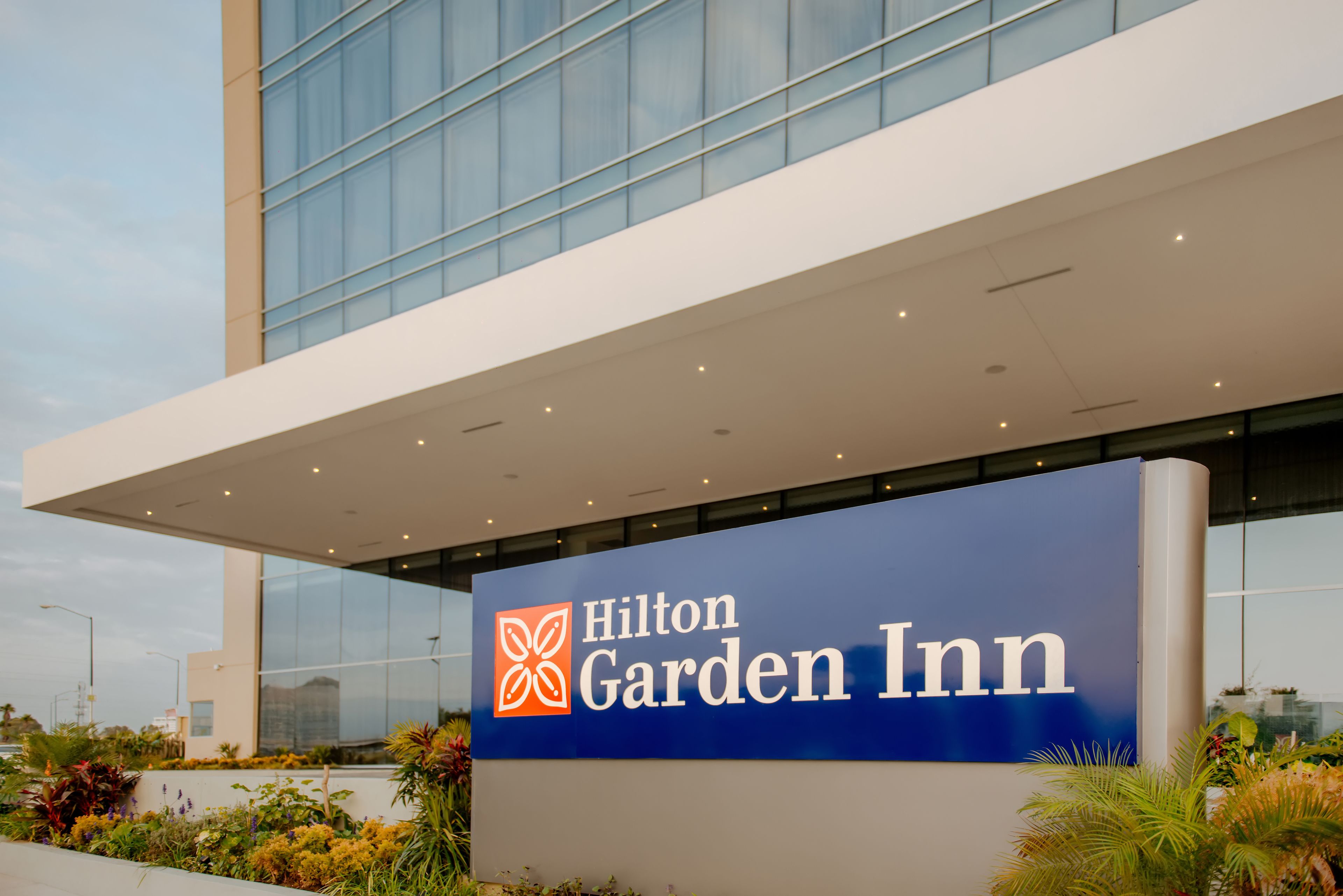 A Hilton Garden Inn sign with a modern building in the background.