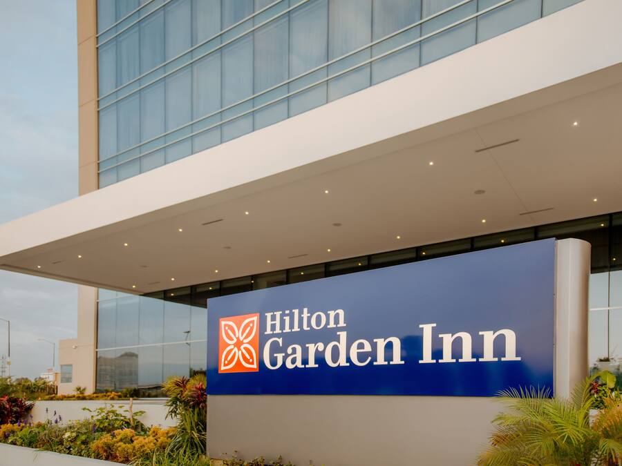 A Hilton Garden Inn sign with a modern building in the background.