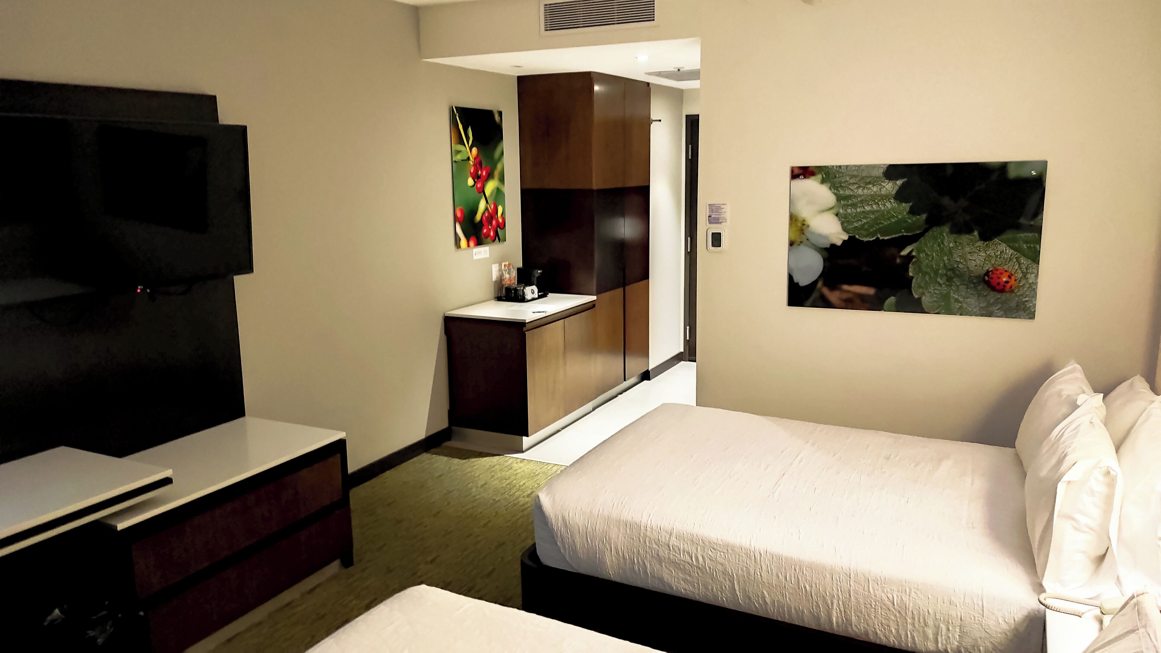 Une chambre d’hôtel équipée d’un lit, d’une télévision, d’un bureau et d’une petite kitchenette.