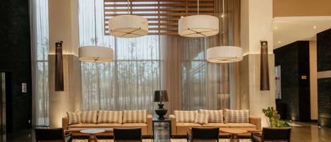 A spacious lobby with a modern sofa set, a coffee table, and a decorative lamp.