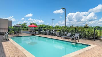 Alberca al aire libre y camastros