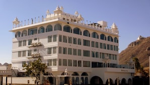 A multi-story building with a white facade, multiple balconies, and arched windows. - Regenta Central Mewargarh Udaipur (Udaipur)