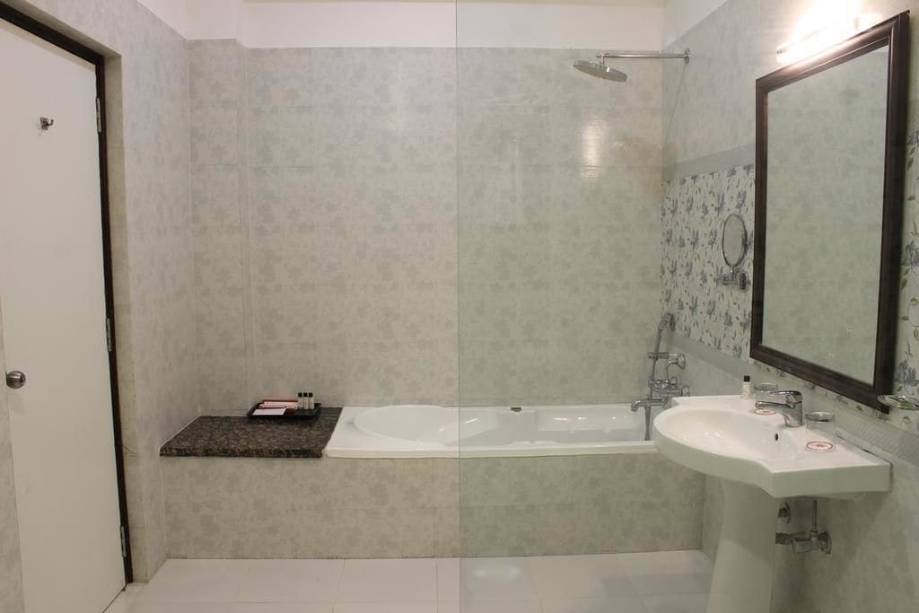 A modern bathroom with a bathtub, a sink, and a shower.