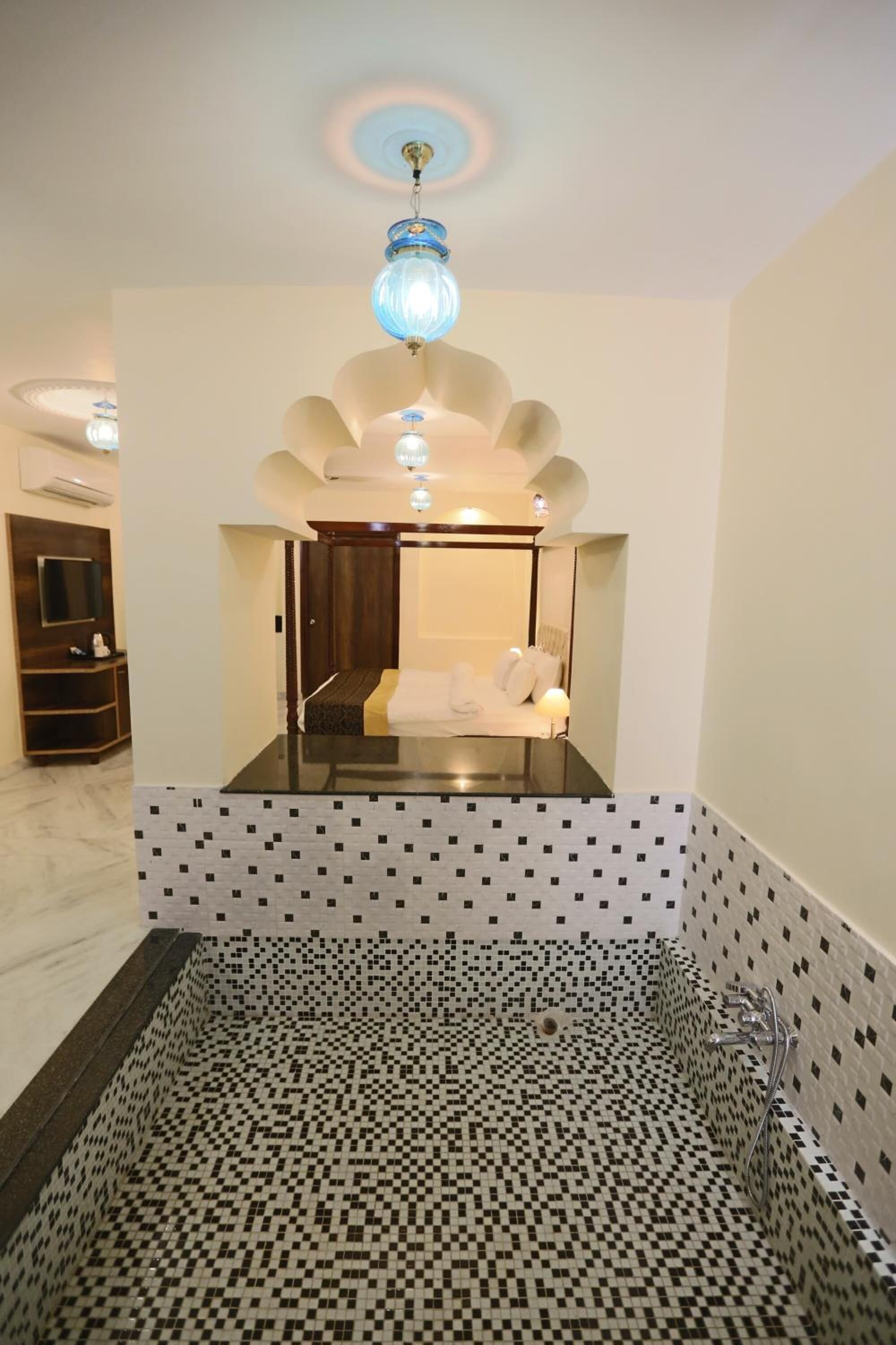 Een moderne badkamer met een douchecabine van glas, een grote spiegel en een plafondlamp.