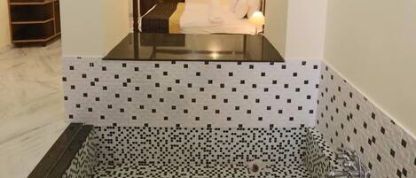 A modern bathroom with a glass-enclosed shower, a large mirror, and a ceiling light fixture.