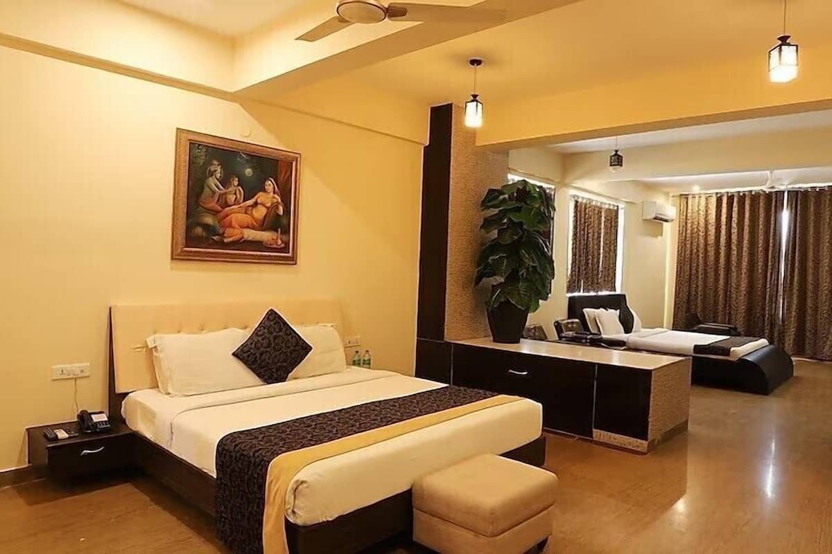 Une chambre d’hôtel comprenant un lit, une table de chevet et un espace bureau.