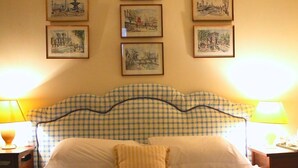 A bed with a checkered headboard, a single pillow, and two bedside lamps. - Stone House Bed and Breakfast (Banbury)