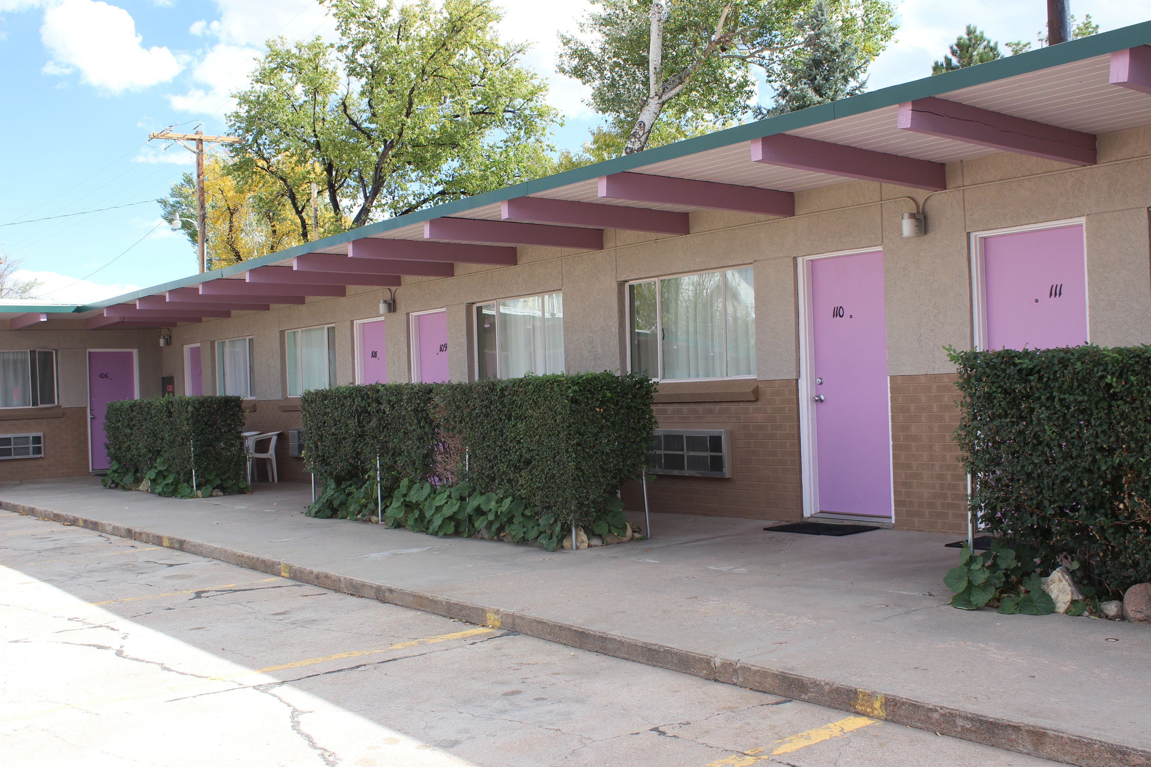 A motel with individual rooms, each with a door number and a window.