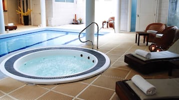 Hotellihuone, jossa on poreallas, aurinkotuoli ja pieni uima-allas.