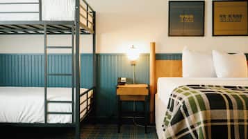 Habitación con literas, un escritorio y una lámpara.