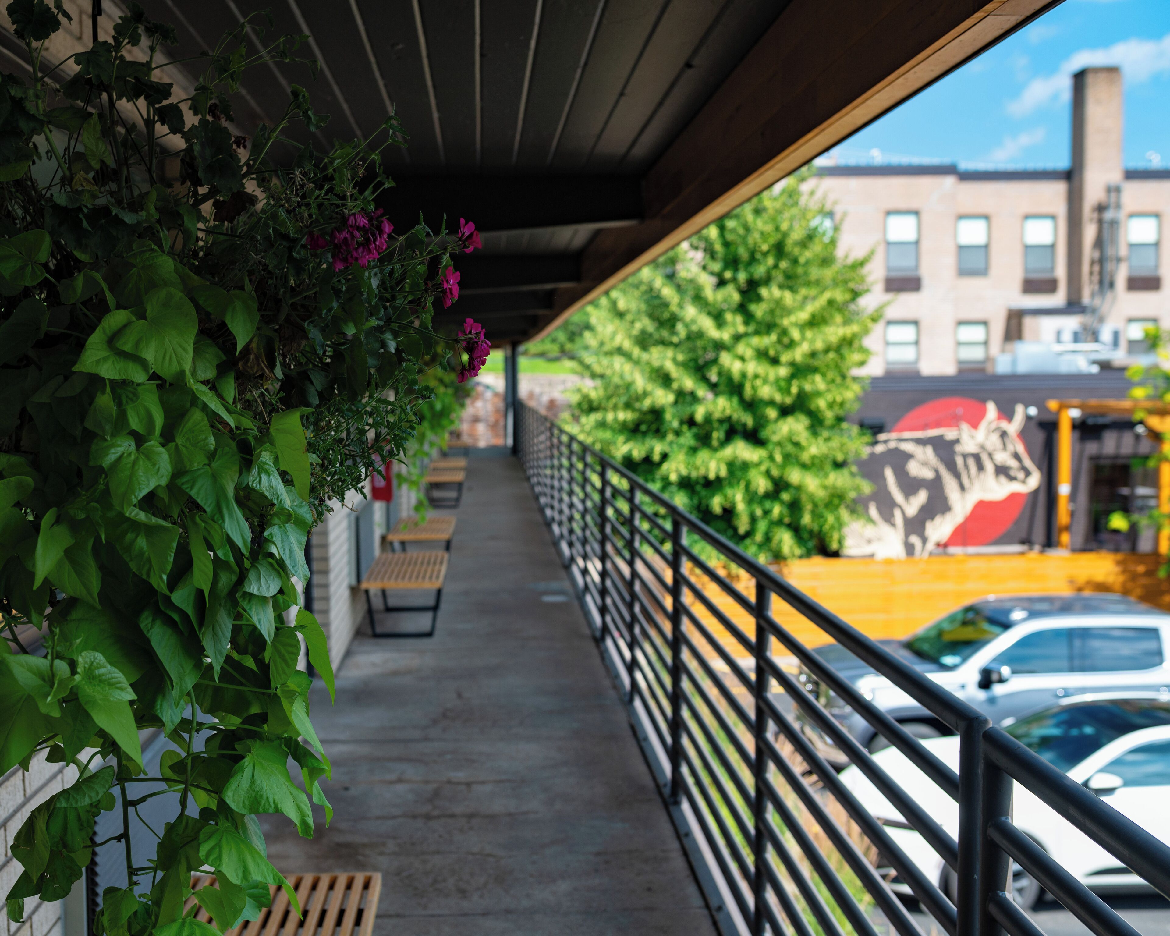 A covered outdoor area with a concrete floor, benches, and a railing.
