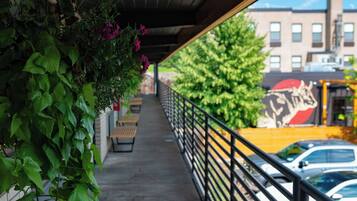 A covered outdoor area with a concrete floor, benches, and a railing.
