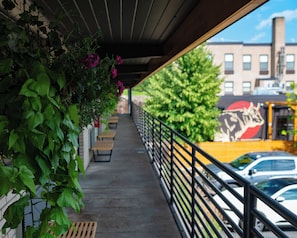 A covered outdoor area with a concrete floor, benches, and a railing.