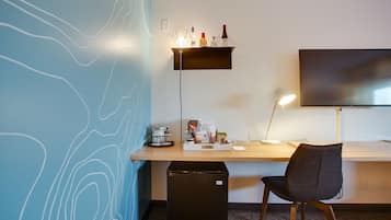 A modern office space with a desk, chair, and a mounted TV.