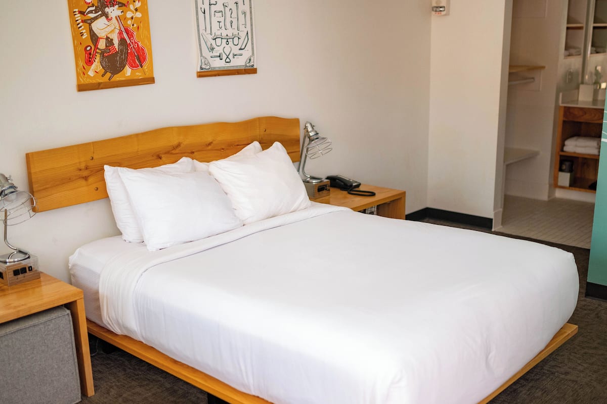 Una cama bien hecha con sábanas blancas en una habitación de hotel.